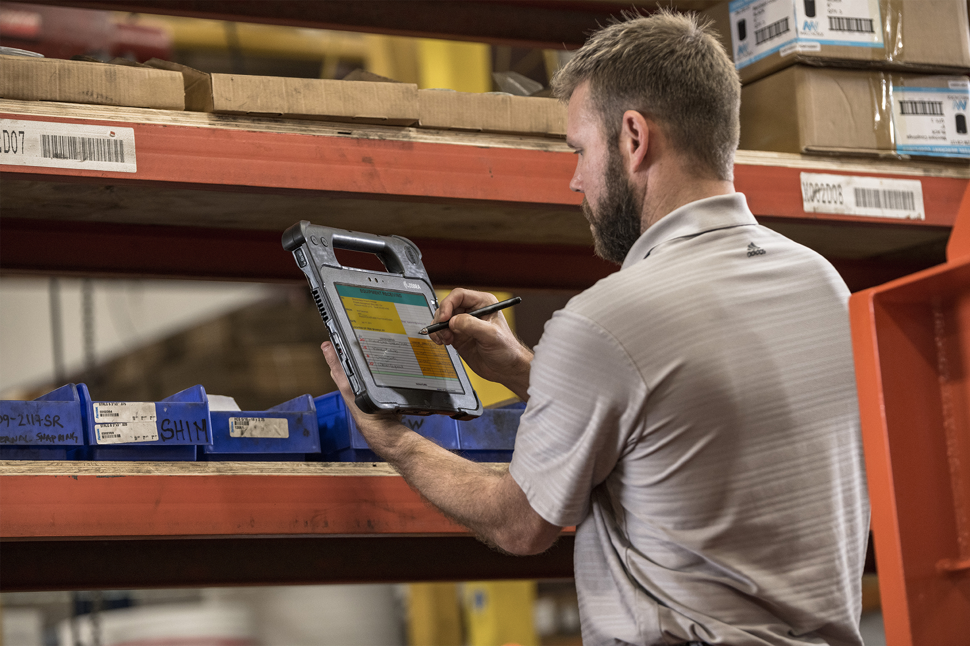 warehouse worker tracking assets on zebra tablet
